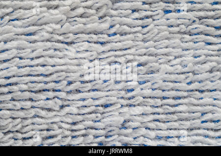 Macro shot of a white towel. Texture is similar to the texture of a fleecy knotted-pile carpet. Geometric pattern of villi on fabric material. White v Stock Photo