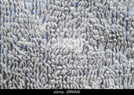 Macro shot of a white towel. Texture is similar to the texture of a fleecy knotted-pile carpet. Chaotically directed white villi on a blue basis Stock Photo