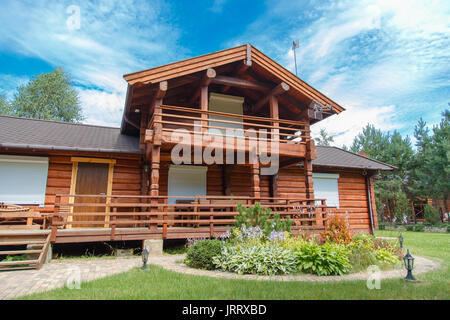 A modern wooden house made of logs. View from outside in summer Stock Photo