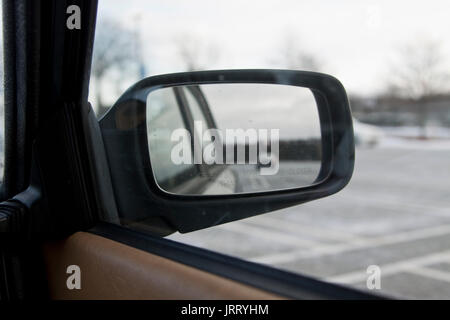 View of wing mirror reading 'Objects in mirror are closer than they appear', on parked car. Stock Photo