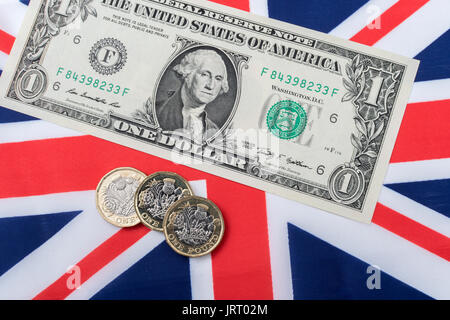 US $1 banknotes / bills with Union Jack and new  £1 / Pound Sterling coins. US Dollar exchange rate concept, US economy, US UK exports. Stock Photo