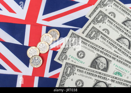 US $1 banknotes / bills with Union Jack and new  £1 / Pound Sterling coins. US Dollar exchange rate concept, US economy, US UK exports. Stock Photo