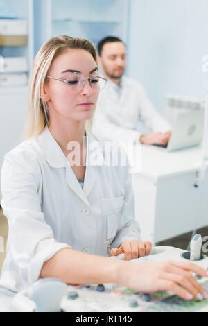 Cheerful young researchers are working in lab. Stock Photo