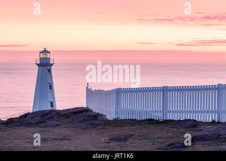 The 1955 concrete Lighthouse and a white picket fence at Cape Spear National Historic Site of Canada at sunrise. Cape Spear, St. John's, Newfoundland. Stock Photo