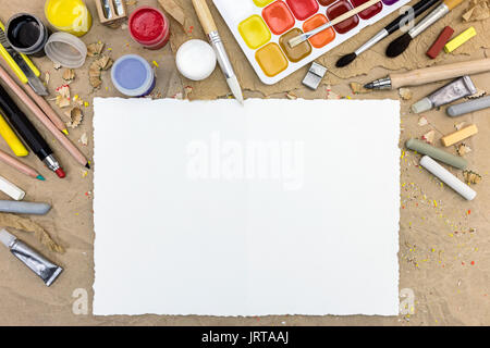 palette with watercolor paints and different size paintbrushes on brown paper background Stock Photo