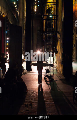 theater, illumination, dramatic art concept. there is another world behind the scenes, and dark silhouette of ballerina on her toes standing out in bright ray of spotlight Stock Photo