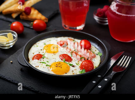 English breakfast - fried egg,  tomatoes and sausage. Stock Photo
