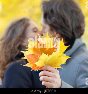 Love, relationship, family and people concept - couple kissing in autumn park Stock Photo