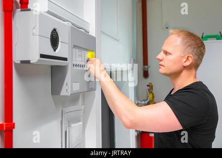 Confident mid adult male IT technician opening fire panel in data center Stock Photo