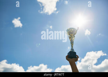 Golden Trophy Cup against Sky Stock Photo