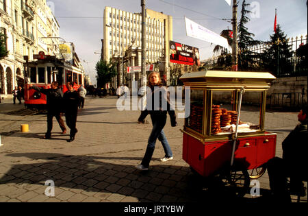Historic Red Tram on Istiklal Caddesi, Beyoglu, Istanbul, Turkey. Simit stnd typical Açma bread selling. Stock Photo