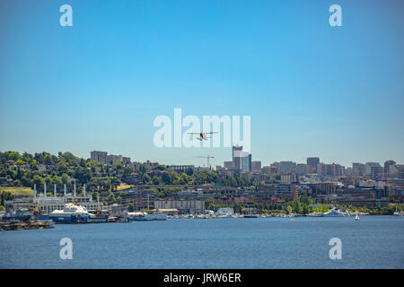Float plane taking off above the buildings. Float plane taking off from the bay in Seattle Washington Stock Photo