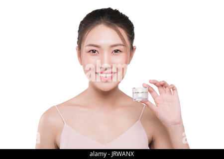 Portrait of beautiful smiling girl with cream bottle in hand. Skin care product Stock Photo