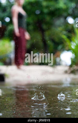 Connecting with mother nature by doing a yoga practice in the rain. Outdoors. Stock Photo