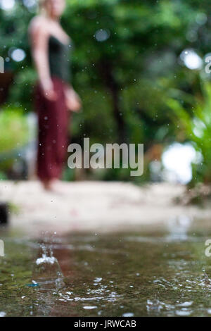 Connecting with mother nature by doing a yoga practice in the rain. Outdoors. Stock Photo