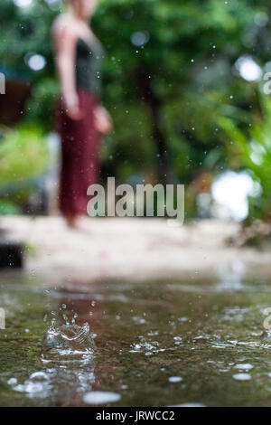 Connecting with mother nature by doing a yoga practice in the rain. Outdoors. Stock Photo