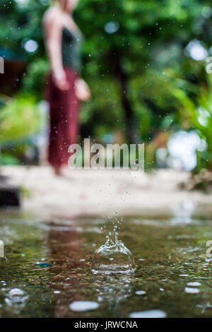 Connecting with mother nature by doing a yoga practice in the rain. Outdoors. Stock Photo