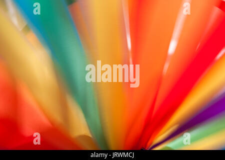 Closeup of the spokes of a colorful pinwheel spinning in the wind on a sunny summer day Stock Photo