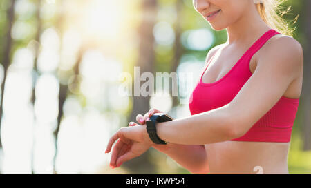 Attractive female athlete using fitness app on her smart watch to monitor workout performance Stock Photo