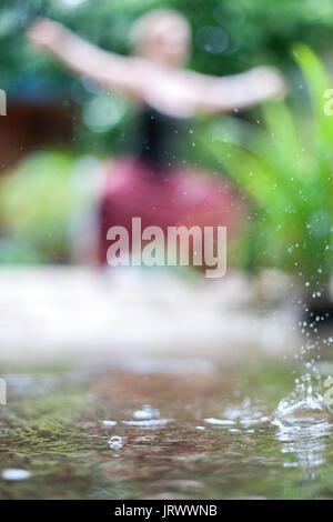 Connecting with mother nature by doing a yoga practice in the rain. Outdoors. Stock Photo