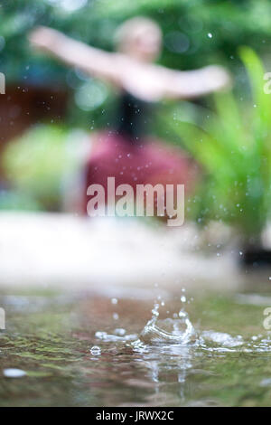 Connecting with mother nature by doing a yoga practice in the rain. Outdoors. Stock Photo