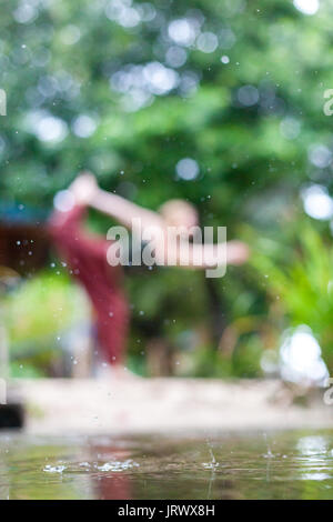 Connecting with mother nature by doing a yoga practice in the rain. Outdoors. Stock Photo