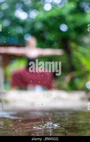 Connecting with mother nature by doing a yoga practice in the rain. Outdoors. Stock Photo