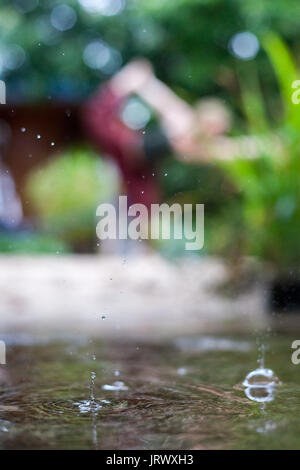 Connecting with mother nature by doing a yoga practice in the rain. Outdoors. Stock Photo