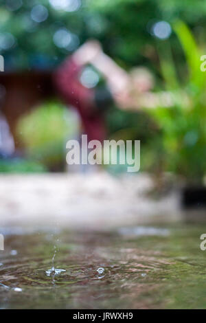 Connecting with mother nature by doing a yoga practice in the rain. Outdoors. Stock Photo