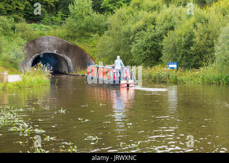 Falkirk, Scotland, UK - August 4, 2017: A person at the helm of a canal barge on the Union Canal near Falkirk in central Scotland. Stock Photo