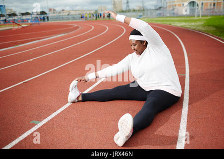 Body positive African woman doing stretching exercise Stock Photo