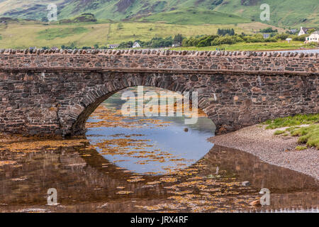 Bridge to Eilean Donan Castle, reflected in the water of the loch. Stock Photo