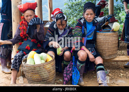 Bac Ha market. Flower black and red dao Hmong people in traditional dress at weekly market, Sapa, Vietnam. Young women from the Flower Hmong minority  Stock Photo