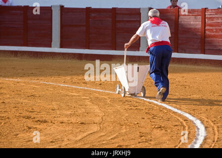 employee of the Bullring painting with a machine the white line of the bullring, Pozoblanco, Spain Stock Photo