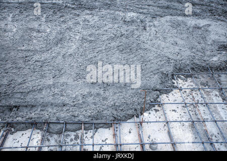 rebar grids with wet cement in concrete floor pouring process Stock Photo