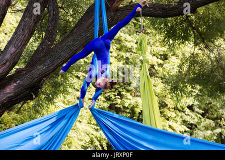 Young gymnast doing exercise on aerial silks Stock Photo