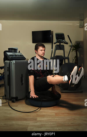 Man in black suit for ems training running on treadmill at ...