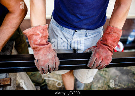 Man measuring off metal bar in workshop. Stock Photo