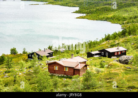 Group Of Small Lakeside Cabins In Mountainous Landscape Location