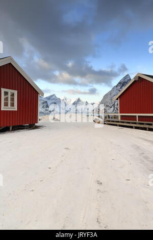 Red wooden rorbuer-traditional seasonal fishing huts-now for tourist use-built with one end on poles in the water. Mounts around Forsfjorden-Kjerkfjor Stock Photo