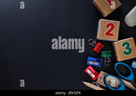 School supplies on a black board with space for text. View from above Stock Photo