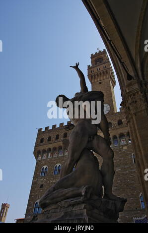 Florence,IT - August 05, 2017 - Silhouette of 'Il ratto delle Sabine' statue by Giambologna, with Palazzo della Signoria in the background. Stock Photo