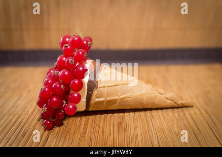An ice cream cone with many red currant Stock Photo