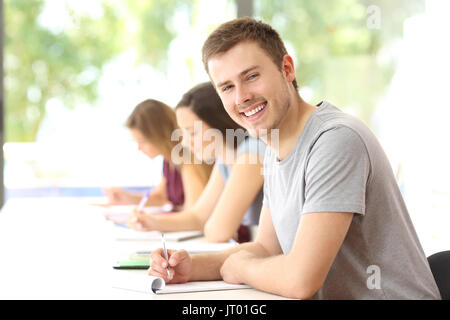 Happy student boy posing in a classroom looking at you Stock Photo