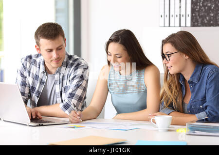 Three happy employees coworking reading documents at office Stock Photo