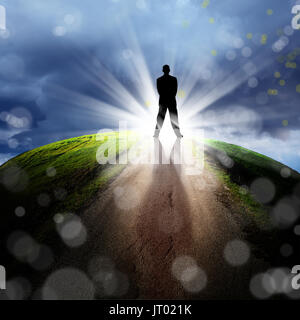 conceptual image of silhouetted businessman on empty road over cloudy sky with beam of light Stock Photo