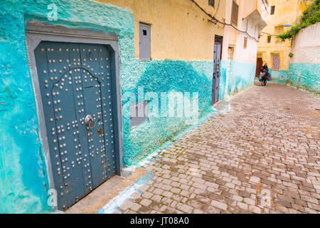 Traditional blue door of a house. Man riding a donkey, Street life scene, Moulay Idriss. Morocco, Maghreb North Africa Stock Photo