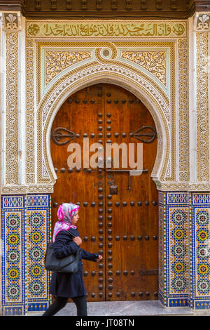 Street life scene. Moulay Idriss Mosque door. Souk Medina of Fez, Fes el Bali. Morocco, Maghreb North Africa Stock Photo