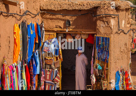 Moroccan traditional clothing store and handicrafts. Ksar Ait Benhaddou, old Berber adobe-brick village or kasbah, Ouarzazate Province. UNESCO World H Stock Photo