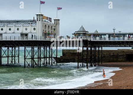A Man Goes Swimming In the Sea Off Brighton Beach, Brighton, Sussex, UK Stock Photo